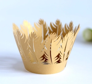 Detailed laser-cut golden feather pattern cake wrapper with intricate hollow texture