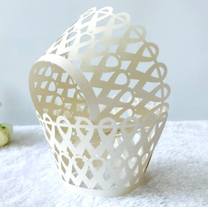 Détail de motifs de cœurs découpés au laser sur contour de gâteau en papier crème