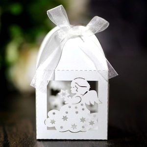 Detail of laser-cut white favor box featuring an angel motif and white ribbon bow