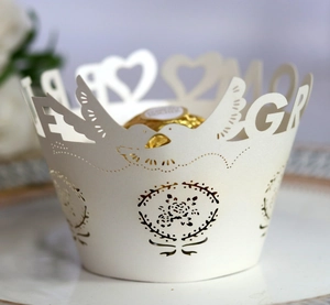 Detailed laser-cut pearl paper cupcake wrapper with heart and bird wedding motifs
