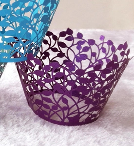 Detailed laser-cut cupcake wrappers with purple vine pattern on plush background
