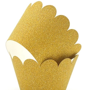 Detail of golden glitter cupcake wrappers with decorative wavy edges for party decor