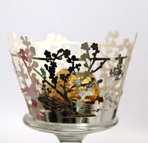 Detail of silver laser-cut cupcake wrapper with tree branch pattern and chocolate