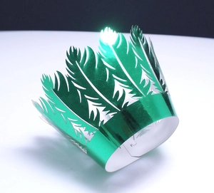 Detail of green metallic paper crown with laser-cut feather design and adjustable slot