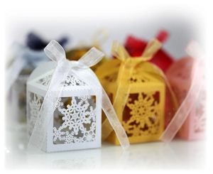 Macro detail of multicolored laser-cut snowflake gift boxes with silk ribbon bows