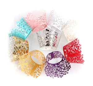 Detailed view of laser-cut cupcake liners with elegant leaf and vine patterns in various colors