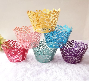 Detailed macro view of laser-cut paper cupcake wrappers with intricate hollow leaf patterns