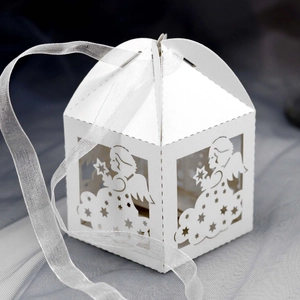 Detail of white laser-cut angel gift box with stars and a delicate white silk ribbon