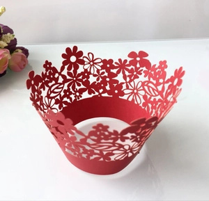Macro detail of red laser-cut floral pattern hollow cupcake wrappers for wedding parties