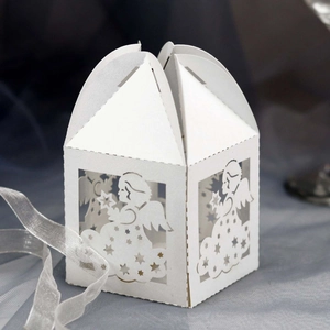 Detailed laser-cut angel and star patterns on white paper candy boxes with ribbon