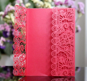 Detail of red laser-cut lace floral pattern on wedding invitation cover