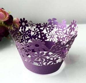 Detail of laser-cut floral pattern on purple paper cupcake wrapper for wedding decor