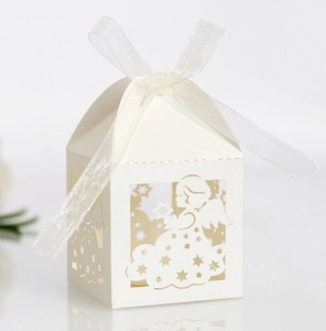 Close-up of laser-cut angel candy box with white organza ribbon for parties