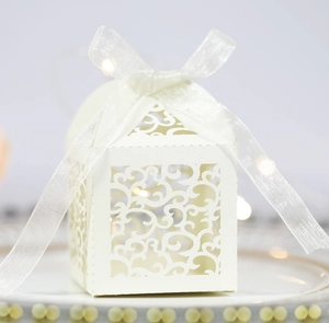 Elegant white laser-cut favor box with ribbon for weddings and candy packaging
