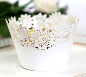 Makroansicht der weißen lasergeschnittenen Muffinförmchen mit Sonnenblumenmuster