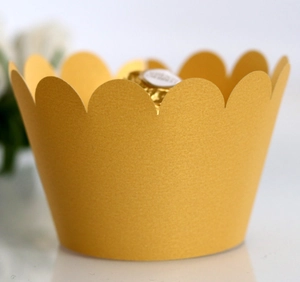 Macro shot of gold metallic cupcake wrapper with wavy edge and elegant glitter finish