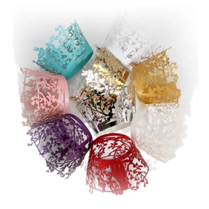 Laser-cut cupcake wrappers with tree patterns in multiple colors for festive party decor