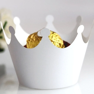 Detailed view of a white crown-shaped cupcake wrapper holding a gold foil chocolate
