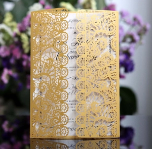 Macro detail of laser-cut gold wedding invitation featuring intricate lace floral patterns