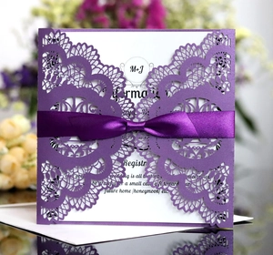 Detailed laser cut purple wedding invitation featuring elegant lace texture and a satin bow