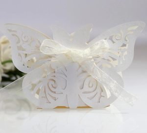 Detailed laser-cut butterfly gift box in pearl white with a silk ribbon for weddings