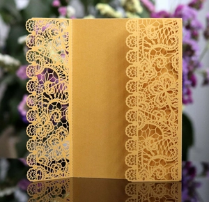 Detail of laser-cut lace floral pattern on elegant pearlescent wedding invitation card