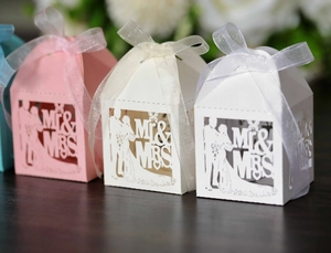 Macro detail of laser-cut Mr & Mrs wedding candy boxes with delicate ribbons