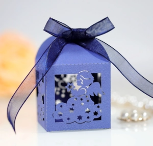 Close-up of laser-cut blue angel favor box with stars and a dark blue organza ribbon bow