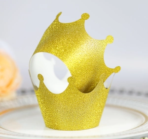 Macro shot of glittering gold crown cupcake wrapper with shimmering glitter texture
