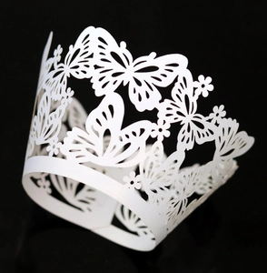 Detailed laser-cut cupcake wrapper with intricate white butterfly and floral patterns