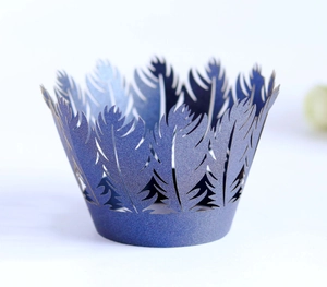 Detailed laser-cut cupcake wrappers in pearlescent blue with feather and pine tree motifs