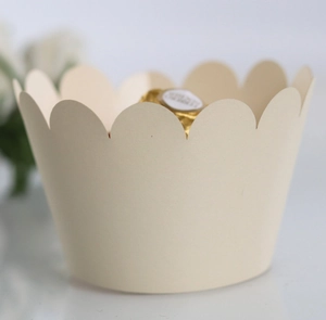 Macro detail of cream paper cupcake wrappers with elegant scalloped lace edges