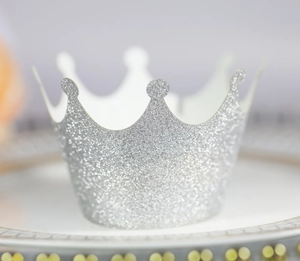 Macro detail of a silver glitter crown cupcake wrapper with fine shimmering texture