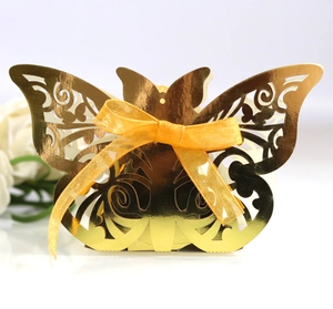Detailed laser-cut golden butterfly favor box with a bright yellow silk ribbon bow