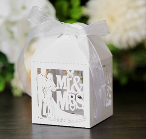 Detail of white laser-cut wedding candy box with Mr & Mrs silhouette and chiffon ribbon