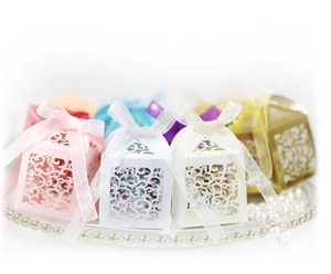Elegant laser-cut wedding favor boxes with silk ribbons in multiple pastel colors