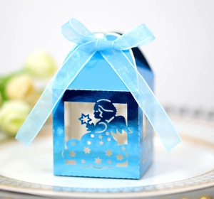 Detail of blue laser-cut angel gift box with stars and a silk ribbon on a plate
