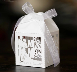 Detail of laser-cut Mr & Mrs wedding candy box with white ribbon and bride silhouette