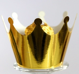 Macro detail of golden crown shaped paper cake wrapper with metallic glossy finish