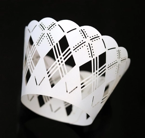 Detailed laser-cut white cupcake wrapper with elegant star and diamond lattice patterns