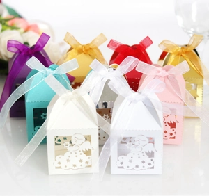 Macro view of laser-cut angel gift boxes with satin ribbons in various colors