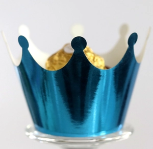 Close-up of metallic blue crown cupcake liner holding a gold foil chocolate ball