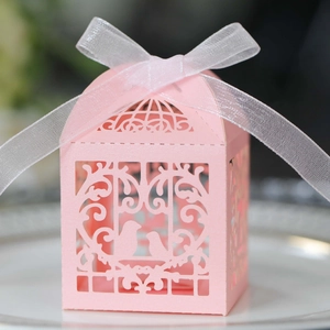 Boîte à dragées rose découpée au laser avec motif d'oiseau et ruban blanc soyeux