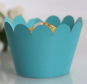 Close-up of mint green scalloped cupcake wrapper with a gold foil candy insert