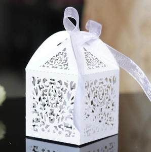 Detail of laser-cut floral pattern on white hexagonal gift box with silk ribbon