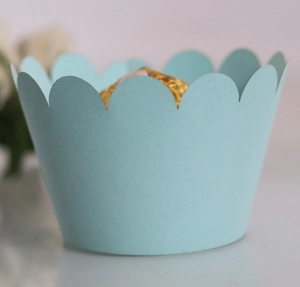 Detail of light blue wave pattern paper cupcake wrapper for elegant dessert table décor