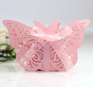 Close-up of pink laser-cut butterfly wedding favor box with a delicate silk bow