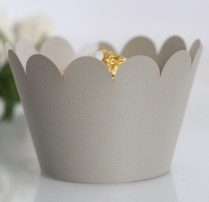 Macro detail of laser-cut scalloped paper cupcake wrapper in pearl light grey finish