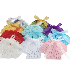 Laser cut shell shaped wedding favor boxes in various colors with ribbon bows