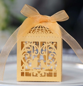 Gros plan d'une boîte de mariage découpée au laser avec ruban jaune et motifs élégants